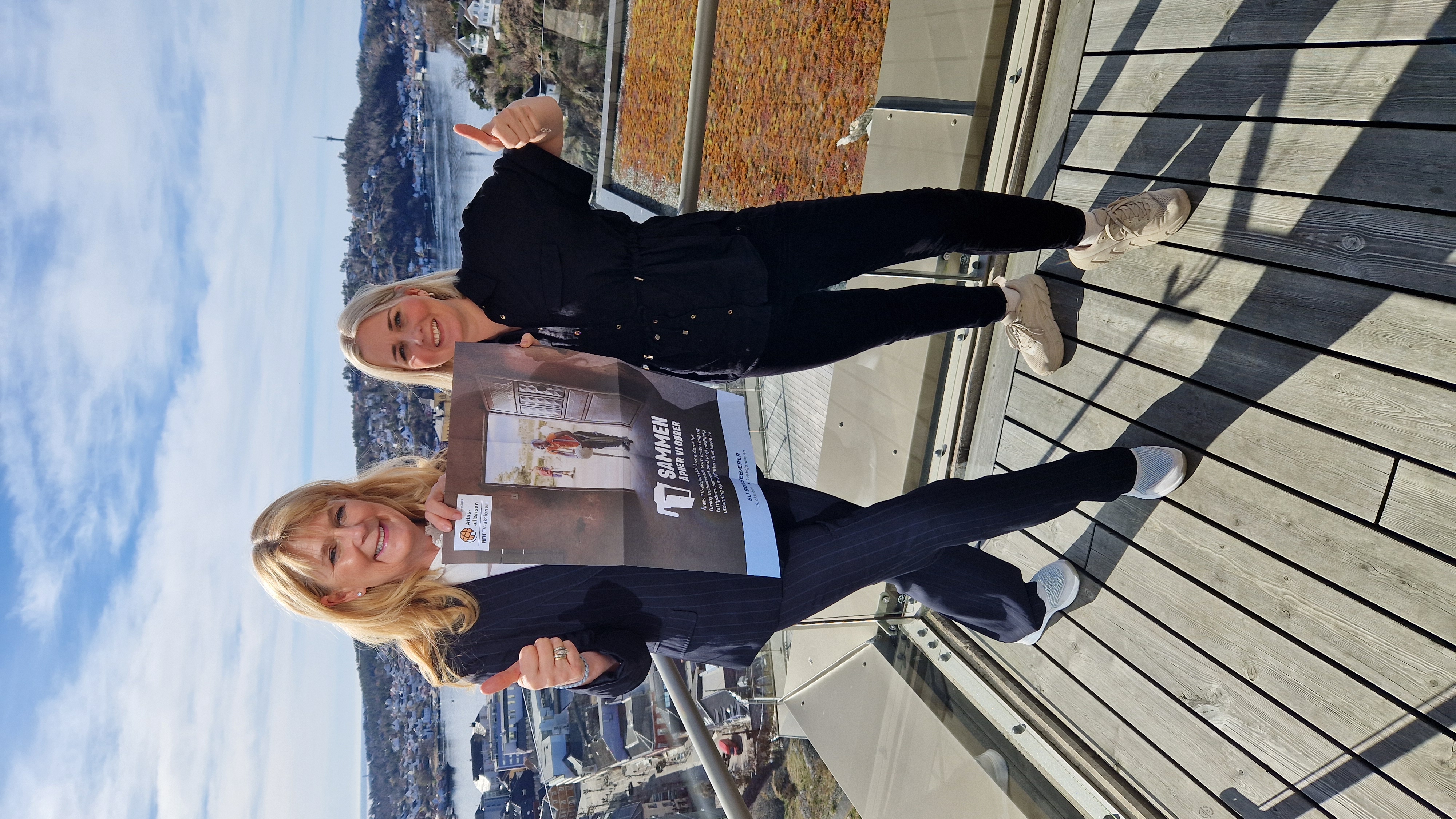 Gina Lund og Helene Knutsen Fosso holder plakat med teksten "Sammen åpner vi dører"